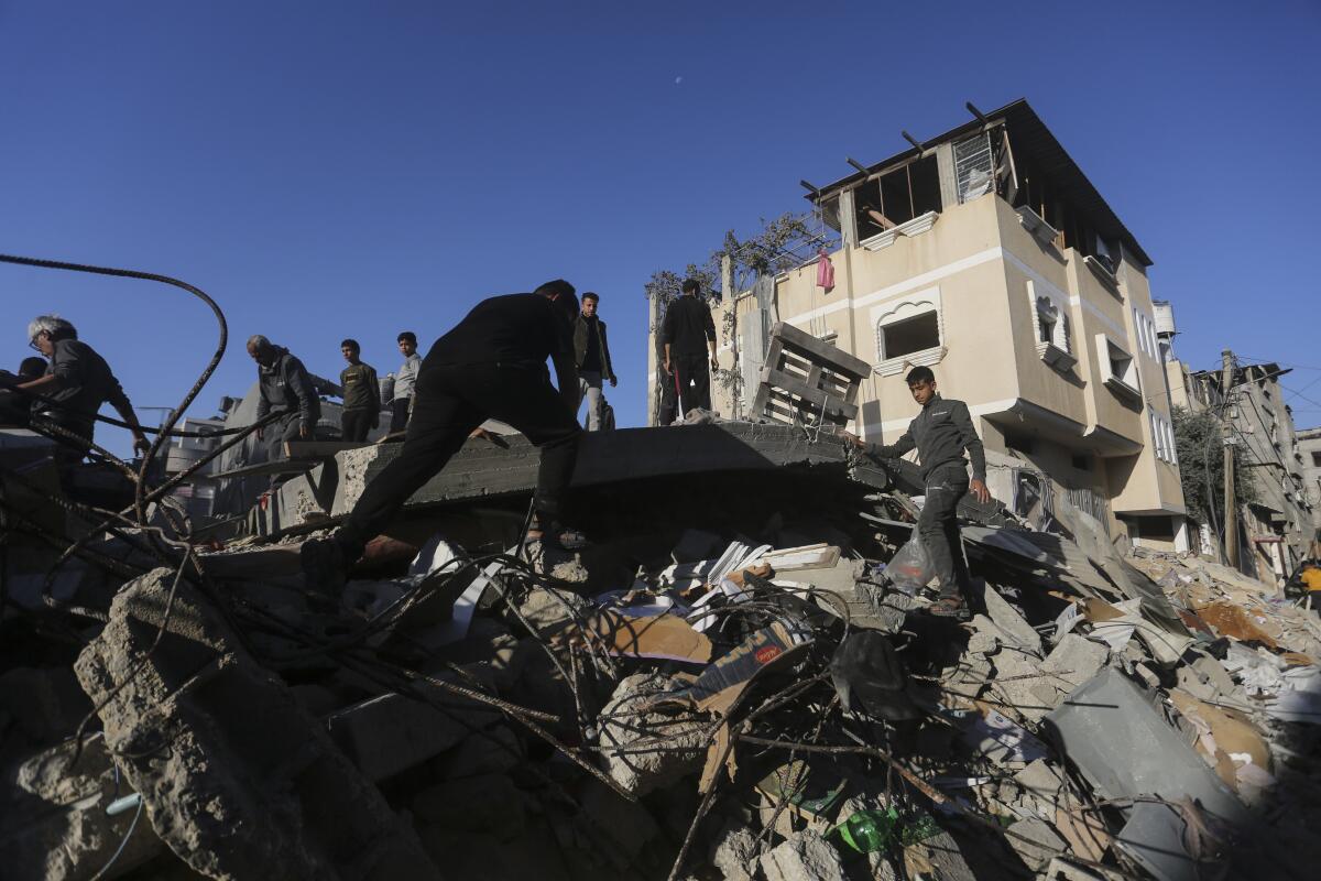 Los palestinos buscan sobrevivientes de un bombardeo israelí sobre la Franja de Gaza, en Rafah,