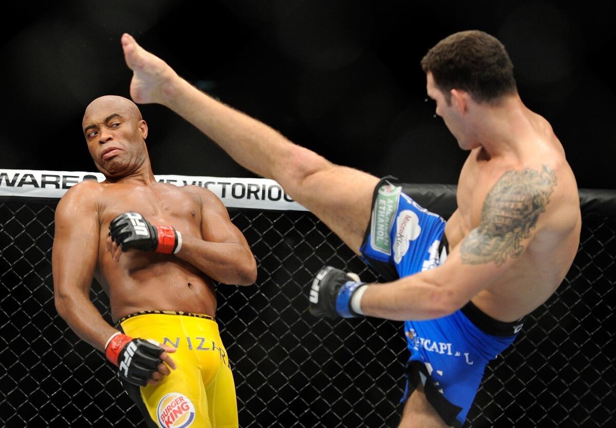 Chris Weidman, right, kicks Anderson Silva during his knockout victory over Silva on July 6. Weidman and Silva will meet again in the octagon at UFC 168 on Dec. 28.
