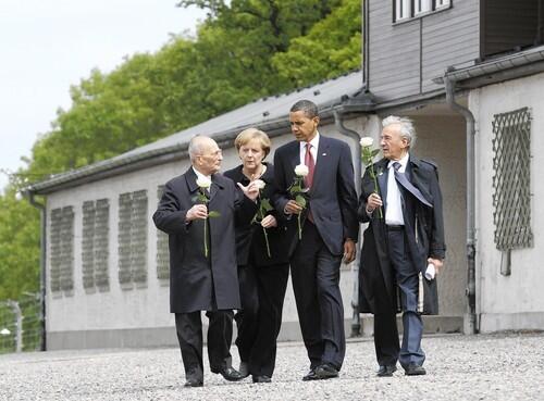 Nazi concentration camp inmates Bertrand Herz (left) and Elie Wiesel (right), with German Chancellor Angela Merkel and President Barack Obama, carry white roses as they visit the camp at Buchenwald near in the eastern German city of Weimar. After policy talks and a news conference in Dresden, Obama visited the camp where 56,000 people perished in the Nazi era.