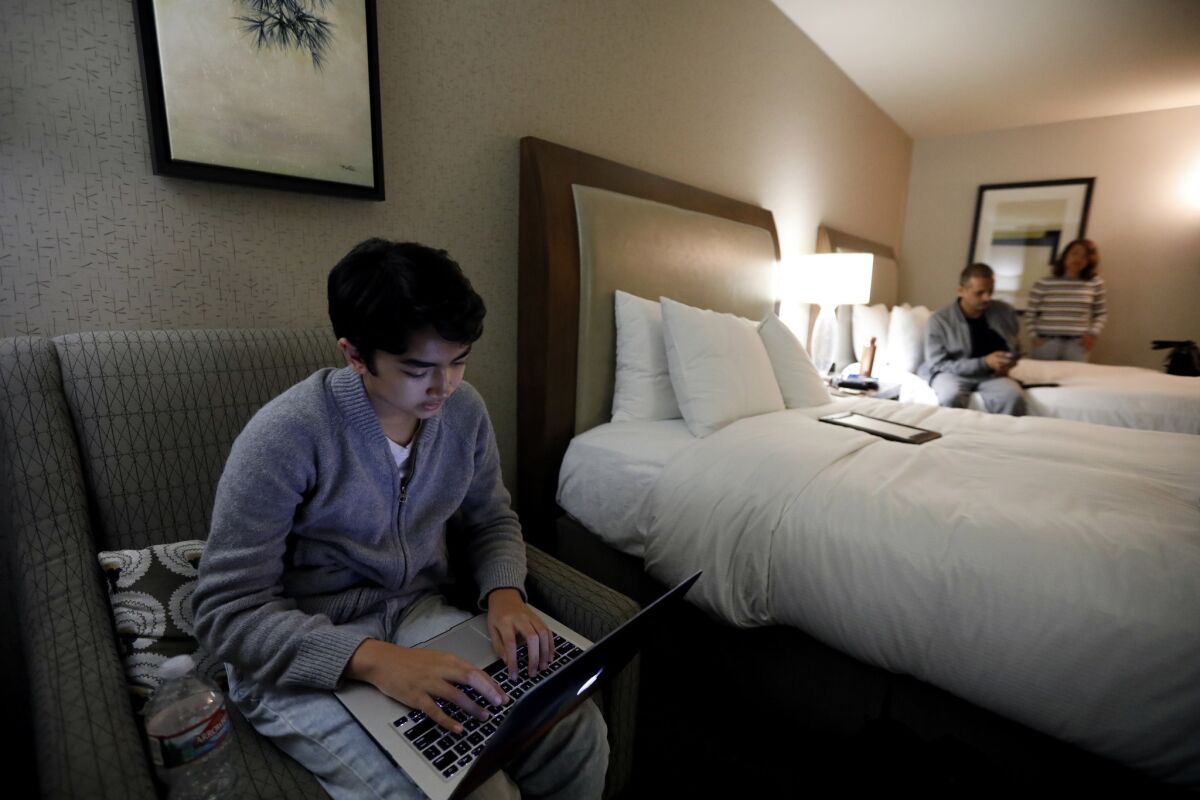 Five days a week they stay at a hotel with their father or mother to be closer to school. (Francine Orr / Los Angeles Times)