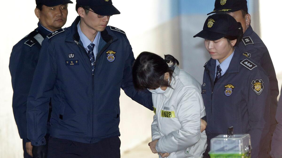 Choi Soon-sil, center, South Korean President Park Geun-hye's longtime friend, arrives for her trial at the Seoul Central District Court in Seoul on Jan. 11, 2017.