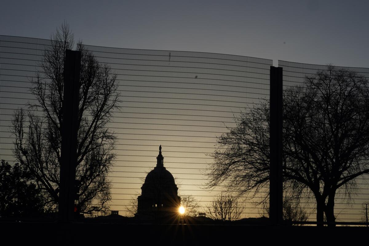 FILE - In this March 4, 2021, file photo the Capitol dome is seen beyond a perimeter security fence at sunrise in Washington. Far right extremist groups like the Proud Boys and Oath Keepers are planning to attend a rally in September at the U.S. Capitol that is designed to demand “justice” for the hundreds of people who have been charged in connection with January’s insurrection, according to three people familiar with intelligence gathered by federal officials. As a result, U.S. Capitol Police have been discussing in recent weeks whether the large perimeter fence that was erected outside of the Capitol after January’s riot will need to be put back up, the people said. (AP Photo/Carolyn Kaster)