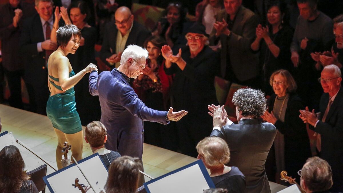 Composer John Adams takes his bows flanked by pianist Yuja Wang and Los Angeles Philharmonic conductor Gustavo Dudamel on Thursday night at Walt Disney Concert Hall, where they premiered Adams' concerto "Must the Devil Have All the Good Tunes?"