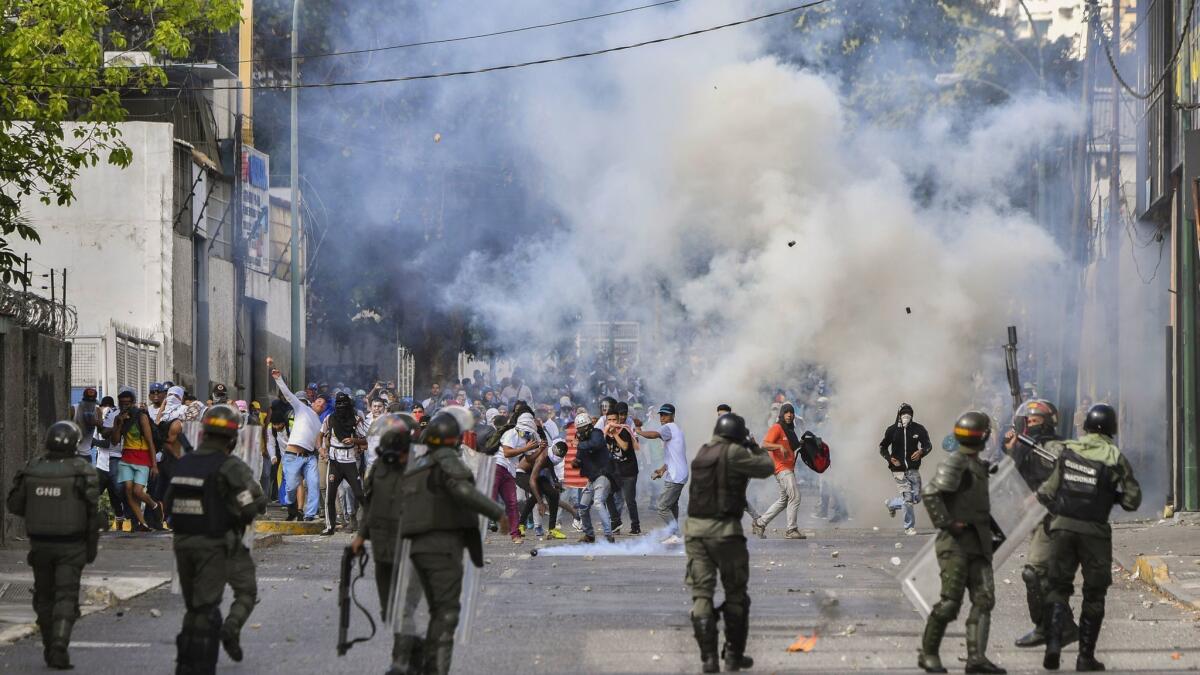 Riot police clash with opposition demonstrators during a protest against the government of President Nicolas Maduro on the anniversary of the 1958 uprising that overthrew a military dictatorship.