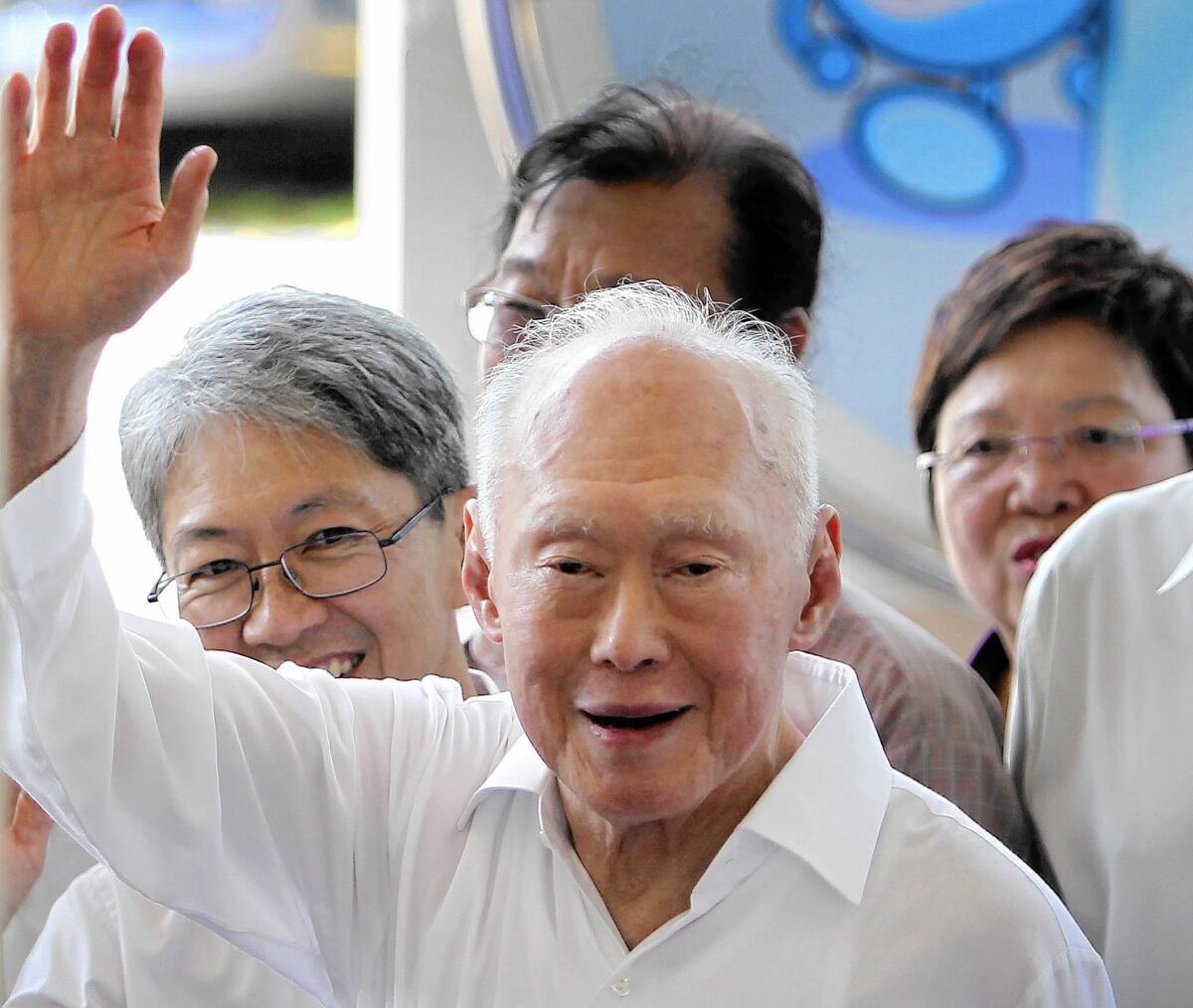 Singapore's former prime minister, Lee Kuan Yew, waves to supporters as he arrives at an elections nomination center in Singapore.