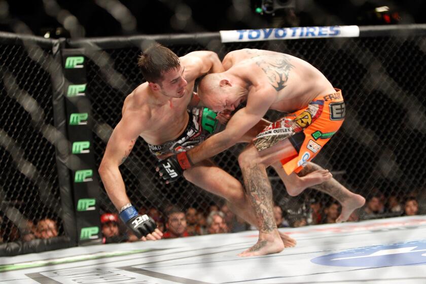 Donald Cerrone (orange trunks) takes down Myles Jury during their UFC lightweight fight on Saturday night at the MGM Grand Garden Arena in Las Vegas.