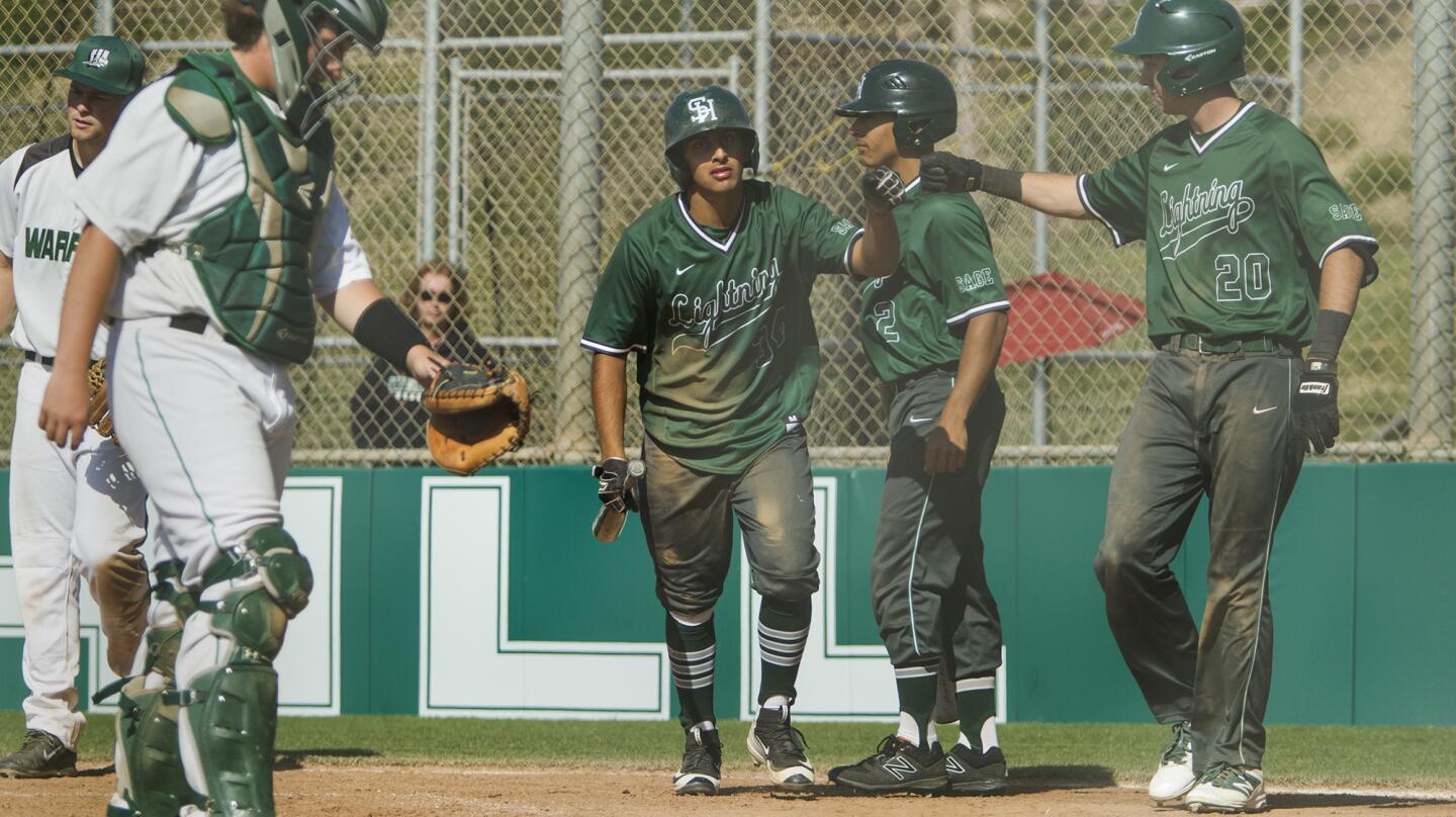 Sage Hill School's Ashwin Chona, center, is greeted at home plate by teammates Jack Pelc and Drake Mossman (20) after Chona hit a two-run homer during the fourth inning against Brethren Christian in an Academy League game on Thursday. (Kevin Chang/ Daily Pilot)