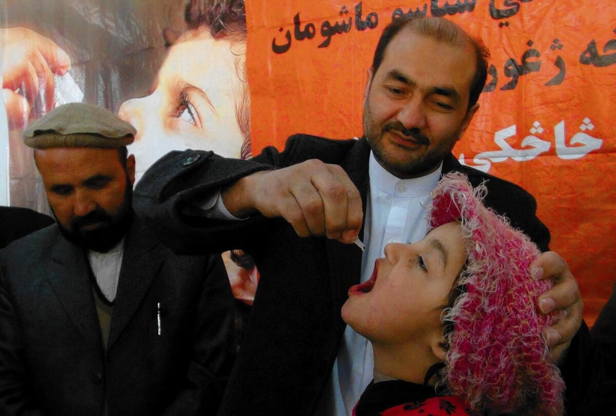 An Afghan health worker administers polio vaccine drops to a child during the first day of a vaccination campaign in Jalalabad, Afghanistan.