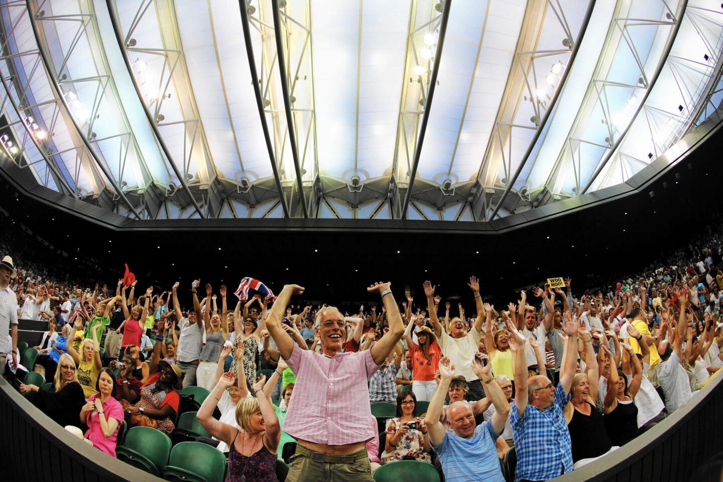 Spectators enjoy the atmosphere under the closed roof on Centre Court as Andy Murray of Great Britain plays Stanislas Wawrinka of Switzerland at Wimbledon in 2009.