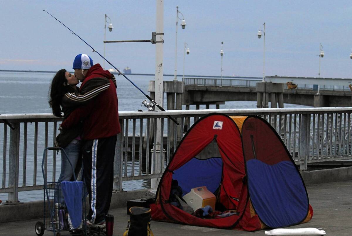 Ana Aguilar and Rene Angeles share a tender moment while fishing at the Belmont Veterans Memorial Pier.
