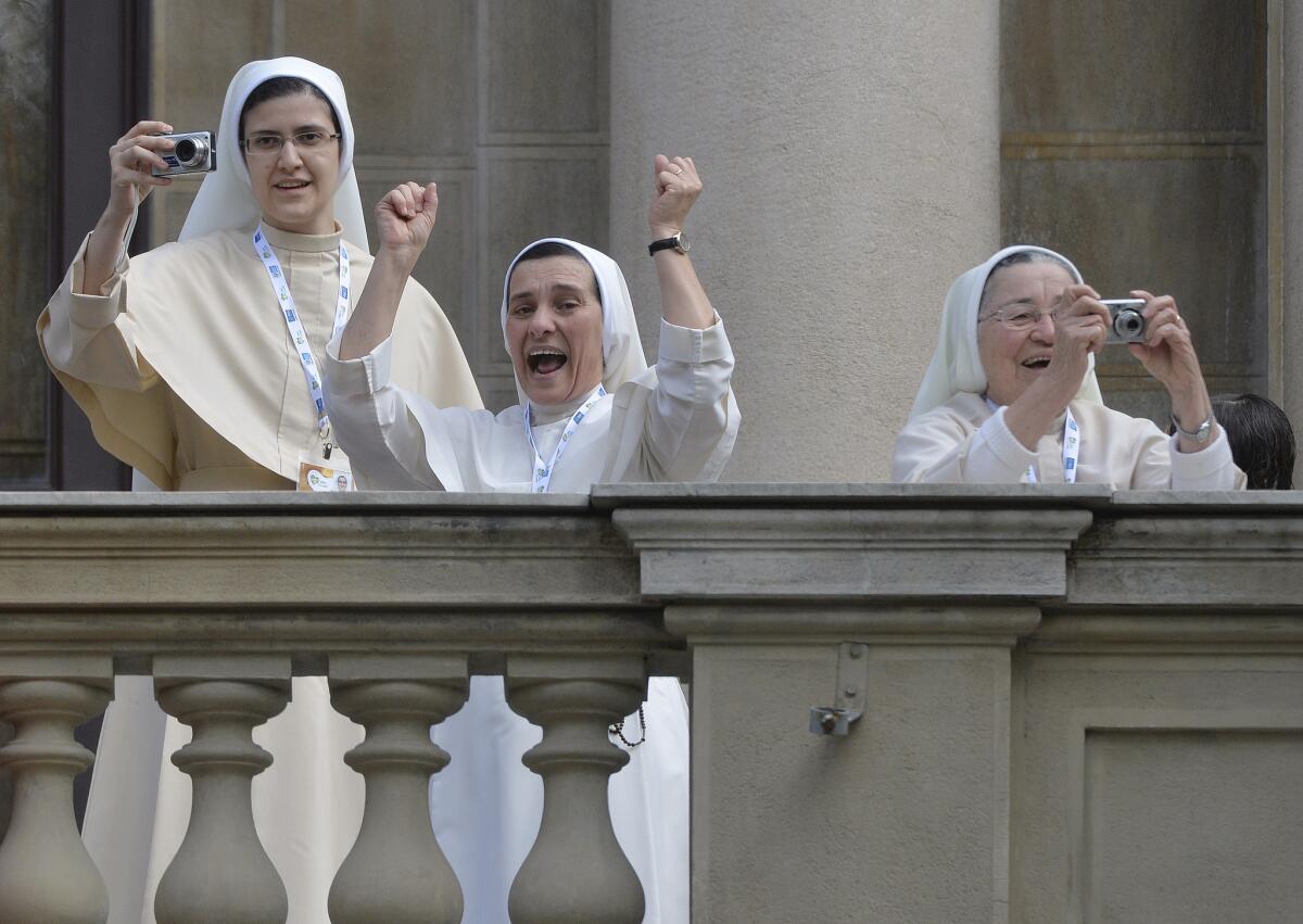 Nuns cheer and take pictures from a balcony as Pope Francis arrives to give the Angelus prayer at Sao Joaquim Palace in Rio de Janeiro.