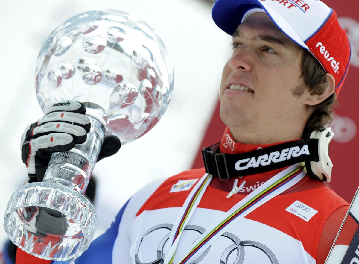 FILE - Switzerland's Carlo Janka shows the trophy of the alpine ski, Men's World Cup overall title, in Garmisch-Partenkirchen, Germany, on March 13, 2010. Once crowned the world's best all-around men's Alpine skier, Swiss racer Carlo Janka ended his racing career Thursday at his home country's most storied venue. Janka's career peaked in 2010 when he was the overall World Cup champion, gold medalist in giant slalom at the Vancouver Olympics and winner of the Lauberhorn downhill at Wengen that is mythic in Switzerland's sports history. (AP Photo/Giovanni Auletta, File)