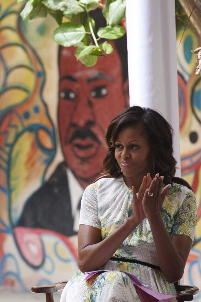 U.S. first lady Michelle Obama claps in front of a mural of Martin Luther King at the all-girls Martin Luther King middle school, in Dakar