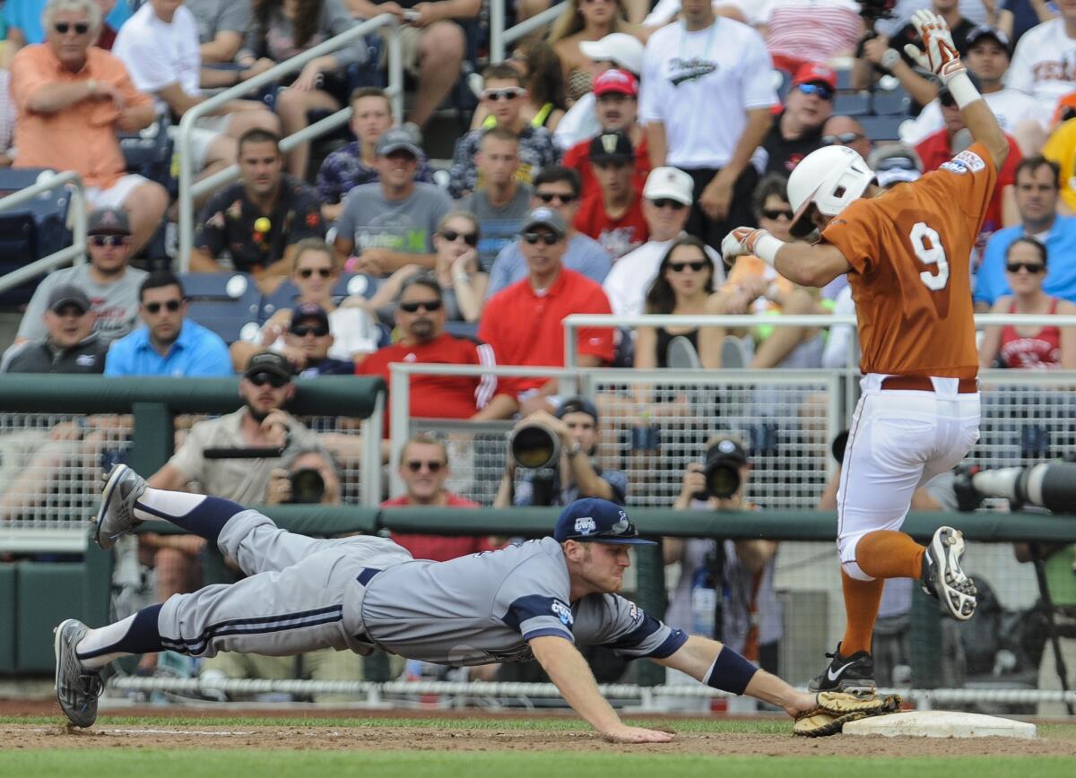 UC Irvine first baseman Connor Spencer, left, leaps to first base as Texas' C.J Hinojosa runs during their College World Series game on Saturday.