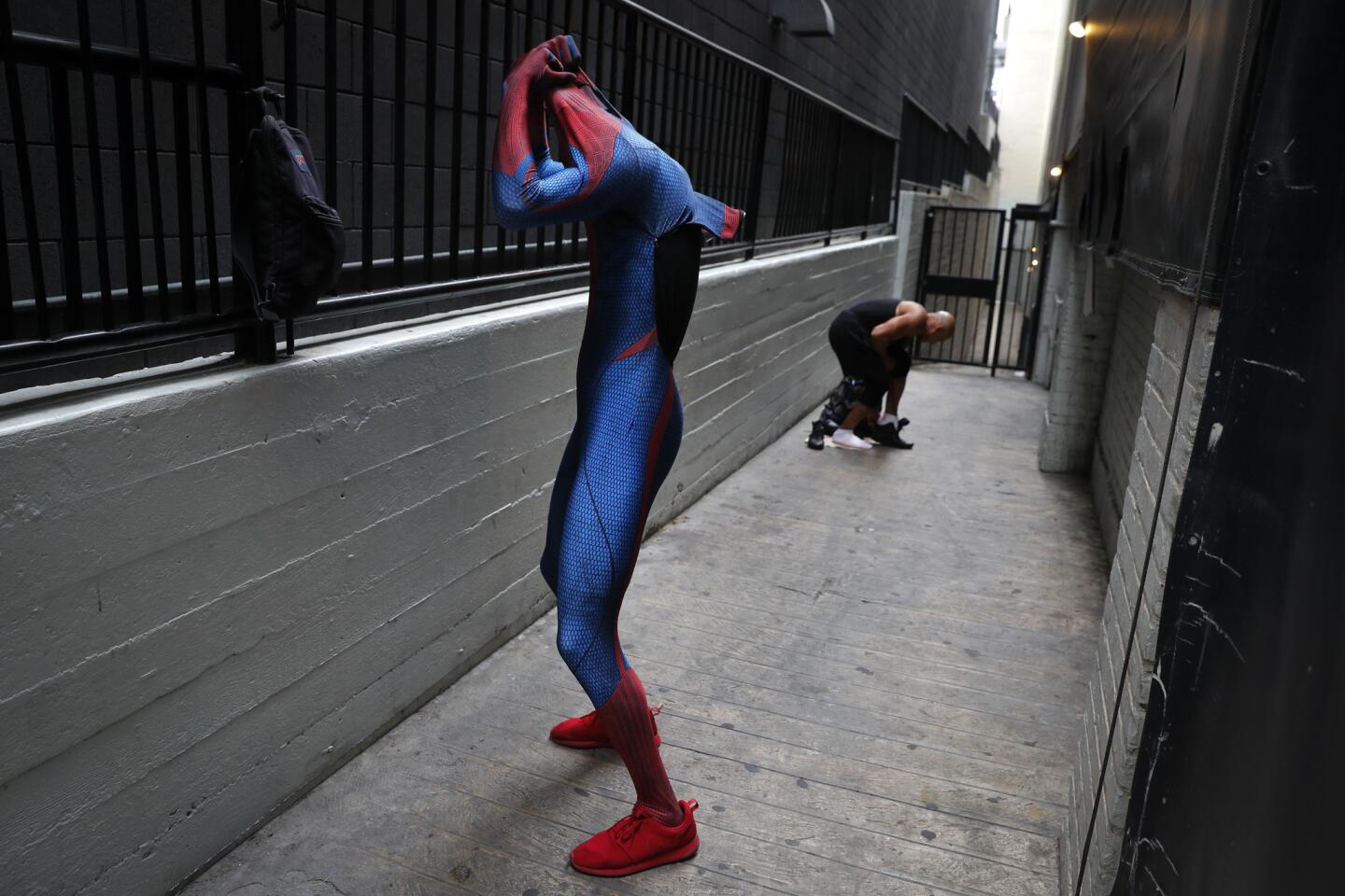 Dos imitadores de Spiderman, Rashad Rouse, enfrente, y Juan Carlos Banegas, de Honduras, cambiándose en el callejón al lado del Teatro Chino TCL tras trabajar tomándose fotos en el bulevar Hollywood, en Los Ángeles.