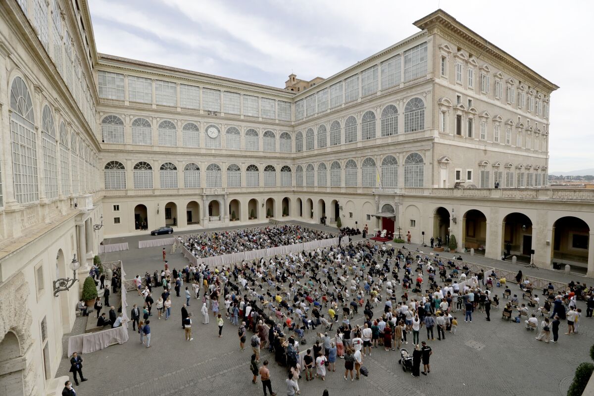 Faithful listen to Pope Francis, white figure sitting at center right, during his general audience, the first with faithful since February when the coronavirus outbreak broke out, at the San Damaso courtyard, at the Vatican, Wednesday, Sept. 2, 2020. (AP Photo/Andrew Medichini)