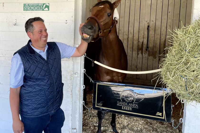 Trainer Phil D'Amato, a Del Mar regular, interacts with his Kentucky Derby horse Stronghold on Wednesday at Churchill Downs in Louisville, Ky.
