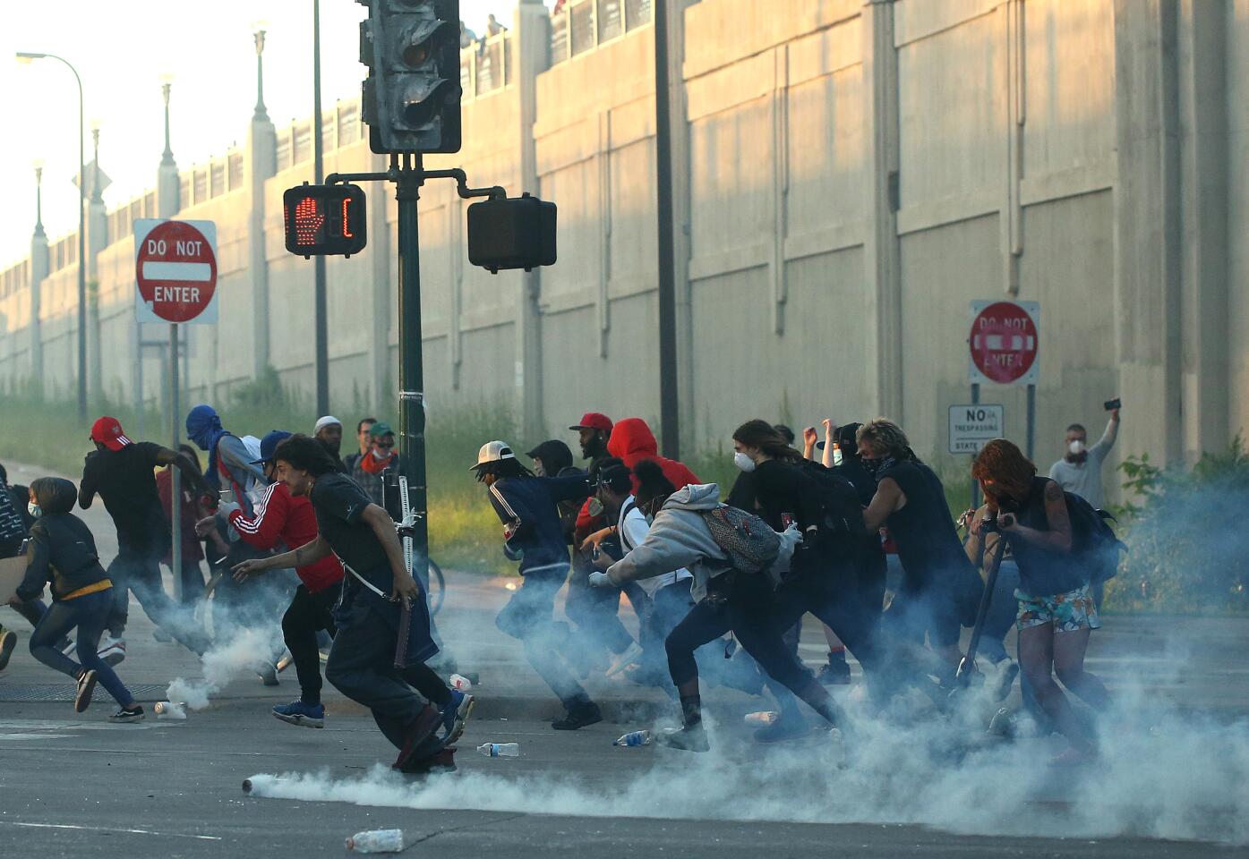 People run as tear gas canisters land near them.