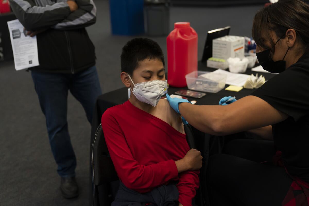 A boy receives a shot in his upper arm