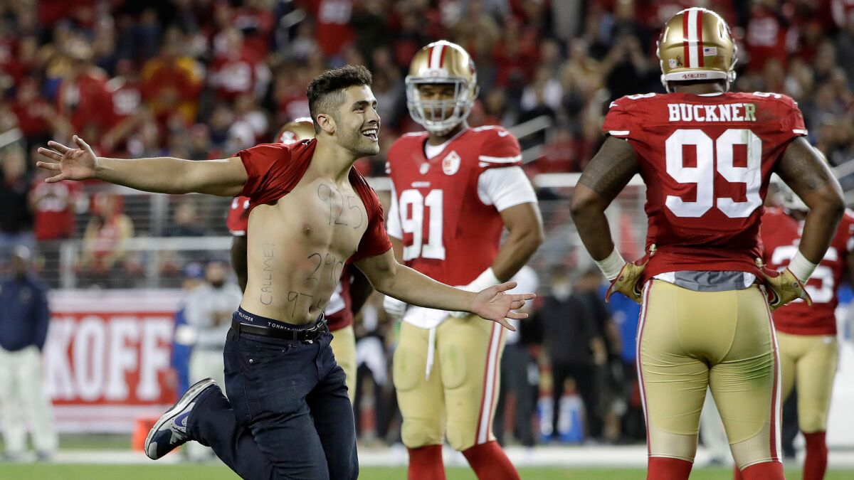 A fan runs on the field during the 49ers-Rams game Monday night.