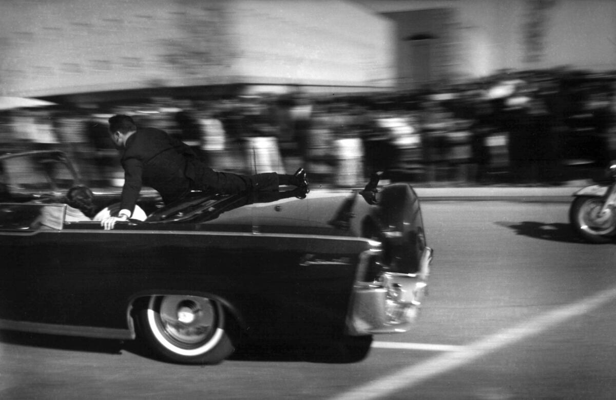 The limousine carrying mortally wounded President John F. Kennedy races toward Parkland Hospital seconds after he was shot in Dallas.