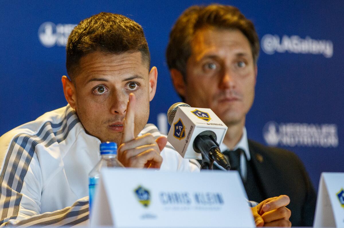 Galaxy star Javier 'Chicharito' Hernández speaks at his introductory news conference in front of Galaxy coach Guillermo Barros Schelotto.