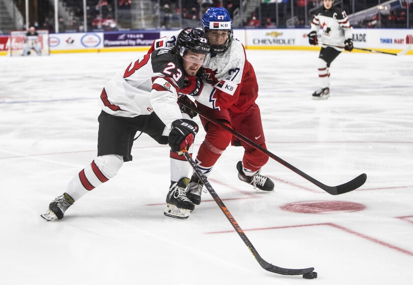 Canada's Mason McTavish (23) and Czech Republic's Jiri Kulich (27) battle for the puck during third-period IIHF world junior hockey championship game action in Edmonton, Alberta, Sunday, Dec. 26, 2021. (Jason Franson/The Canadian Press via AP)