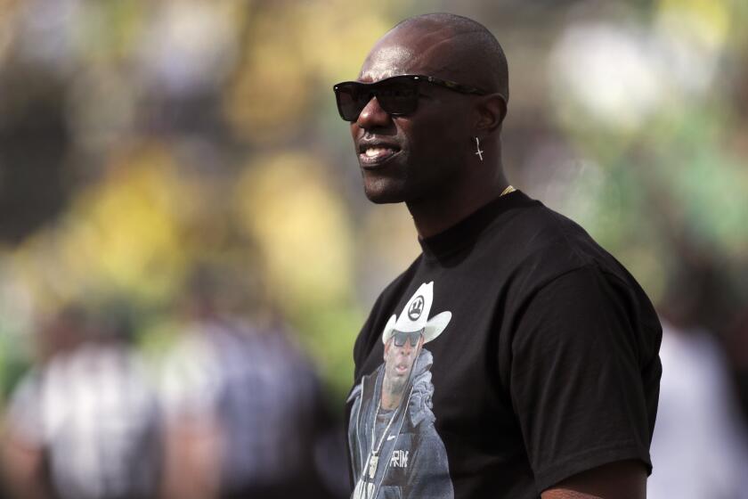 Former NFL football player Terrell Owens looks on during warm ups before an NCAA football game between Colorado and Oregon