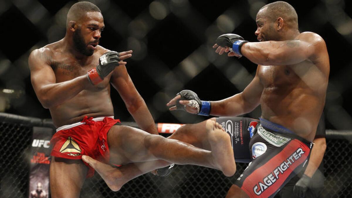 Jon Jones, left, and Daniel Cormier trade kicks in the middle of the octagon during UFC 182 at the MGM Grand Garden Arena in Las Vegas on Jan. 3, 2015.