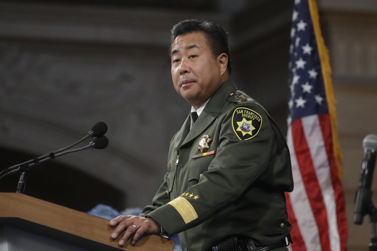 San Francisco Sheriff Paul Miyamoto speaks at a lectern.