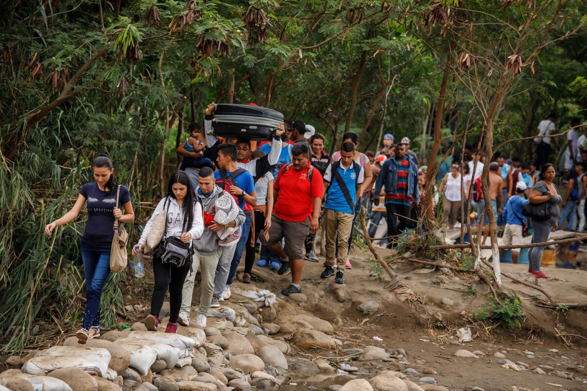 Venezuelans cross the border into Colombia last month. Millions are seeking asylum in other nations.