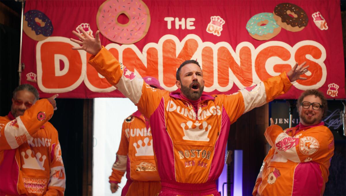 Ben Affleck raises his arms during a Dunkin' Donuts commercial
