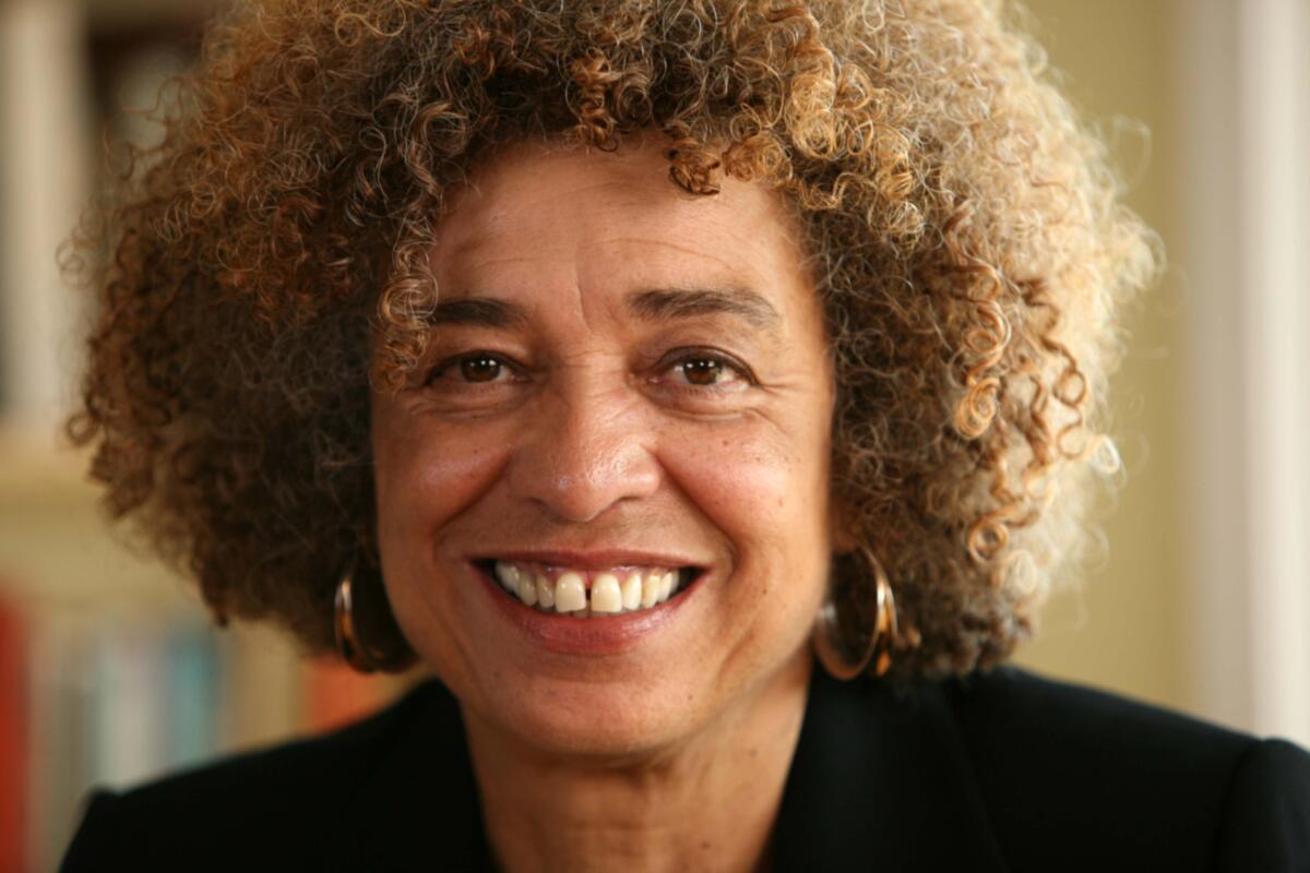 A woman with curly hair smiles for the camera.
