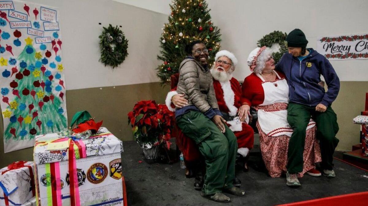 Ann Brown, left, and Alicia Bonskowski, both of the U.S. Forest Service, take a break with Santa Claus and Mrs. Claus (David Munger and Molly Williams).