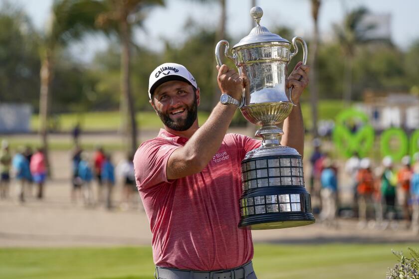 Jon Rahm, of Spain, holds the championship trophy after winning the Mexico Open.
