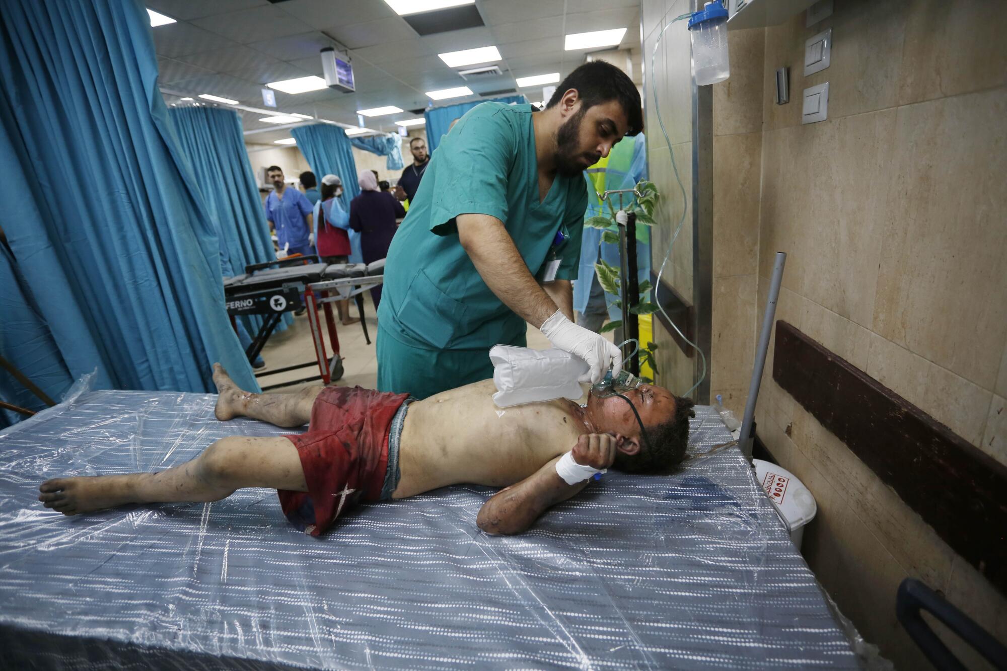 A doctor examines a child injured in Israeli attacks.