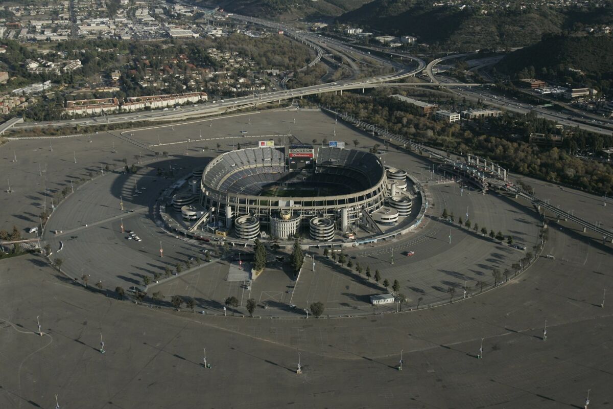 Aerial view of Qualcomm Stadium with its surrounding expansive parking lot. Interstate 8 is to the right. Interstate 15 above and to the left of stadium.