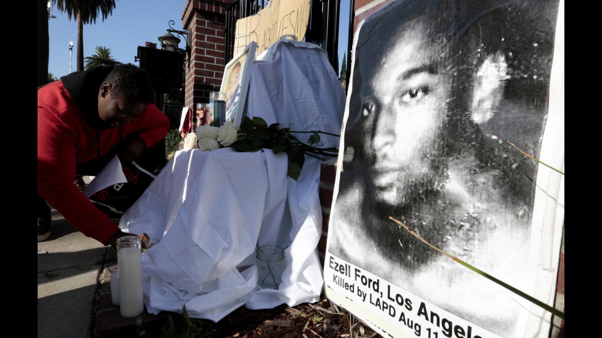 An activist with Black Lives Matter lights candles at an altar for Ezell Ford in front of L.A. Mayor Eric Garcetti's residence on June 8 over the recent ruling by the police in the death of Ford.