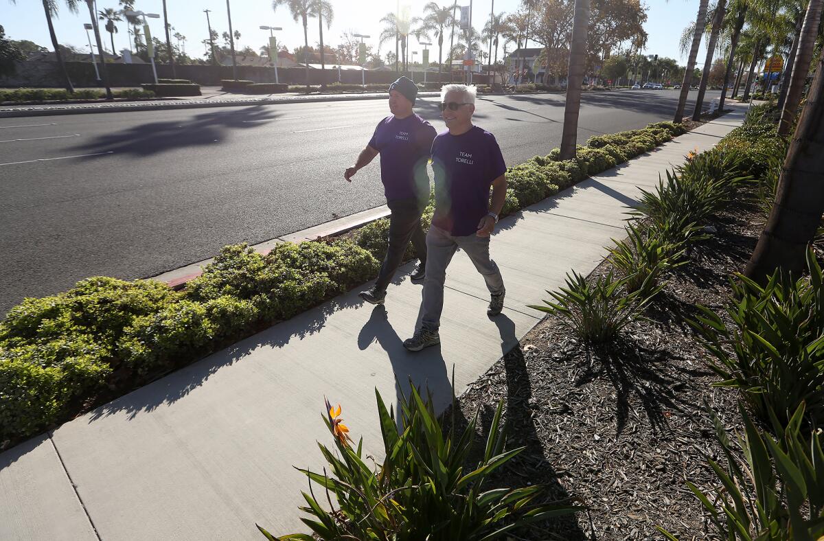 Matt Weich and Danny Wexler, from left, walk up Harbor Blvd in Costa Mesa on Monday. 