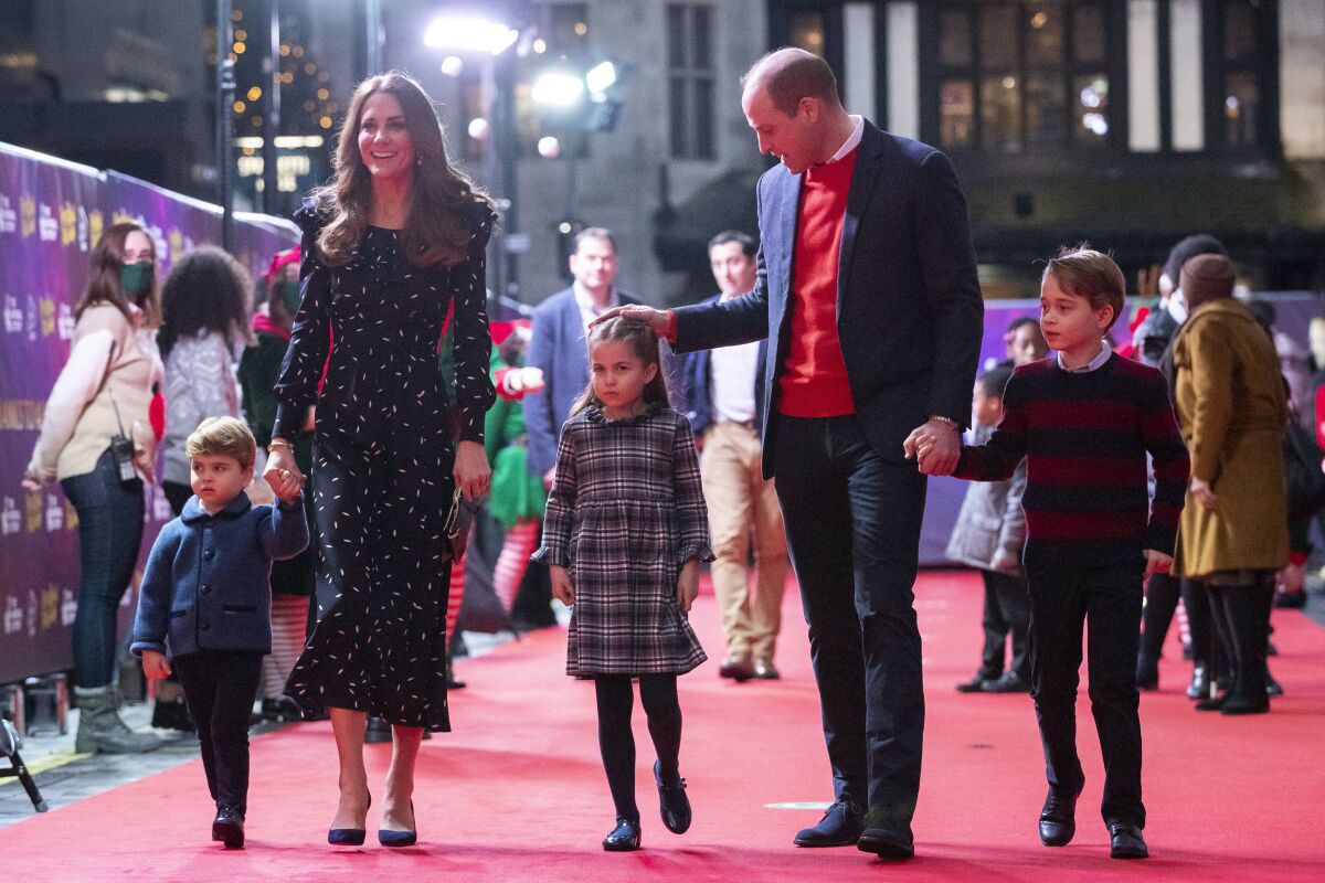 Britain's Prince William and Kate, Duchess of Cambridge talk to Dom Warren and family, the founder of Dom's Food Mission, as they attend a special pantomime performance at London's Palladium Theatre, Friday Dec. 11, 2020, hosted by The National Lottery, to thank key workers and their families for their efforts throughout the COVID-19 pandemic. (Aaron Chown/Pool via AP)