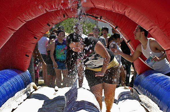 Music fans cool off in a water slide at the Warp Tour in Pomona where the temperatures were in the triple digits.
