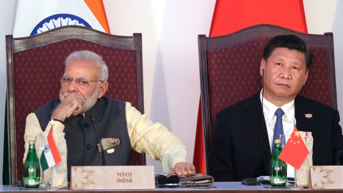 Indian Prime Minister Narendra Modi, left, and Chinese President Xi Jinping listen to a speech during a summit in Goa, India, in 2016.