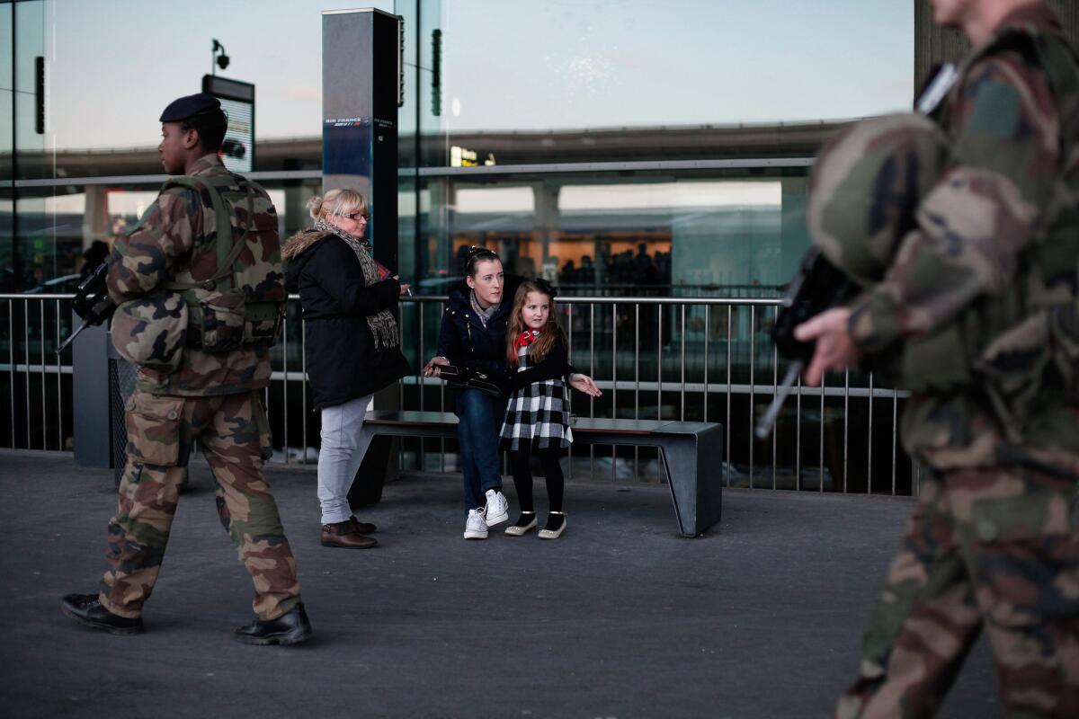 A girl watches French soldiers patrolling at Charles de Gaulle airport in Roissy, north of Paris.