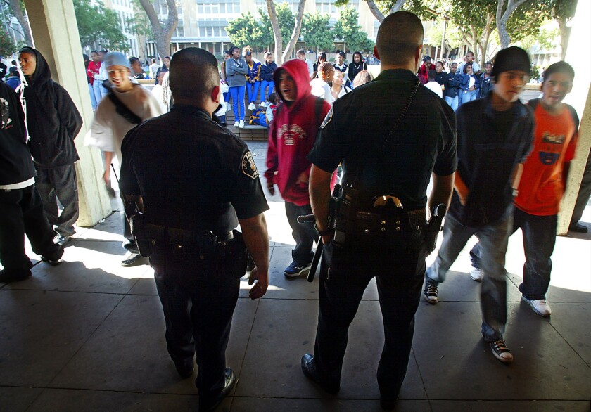 Los Angeles Unified School District Police Officers Alfred Navarro, left, and Luis Barraza keep an eye on students during lunch break at Crenshaw High School in Los Angeles.
