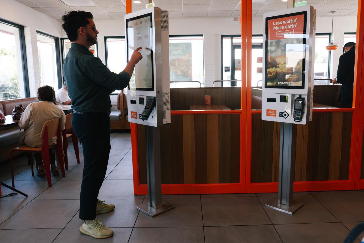 A customer uses a fast-food kiosk.