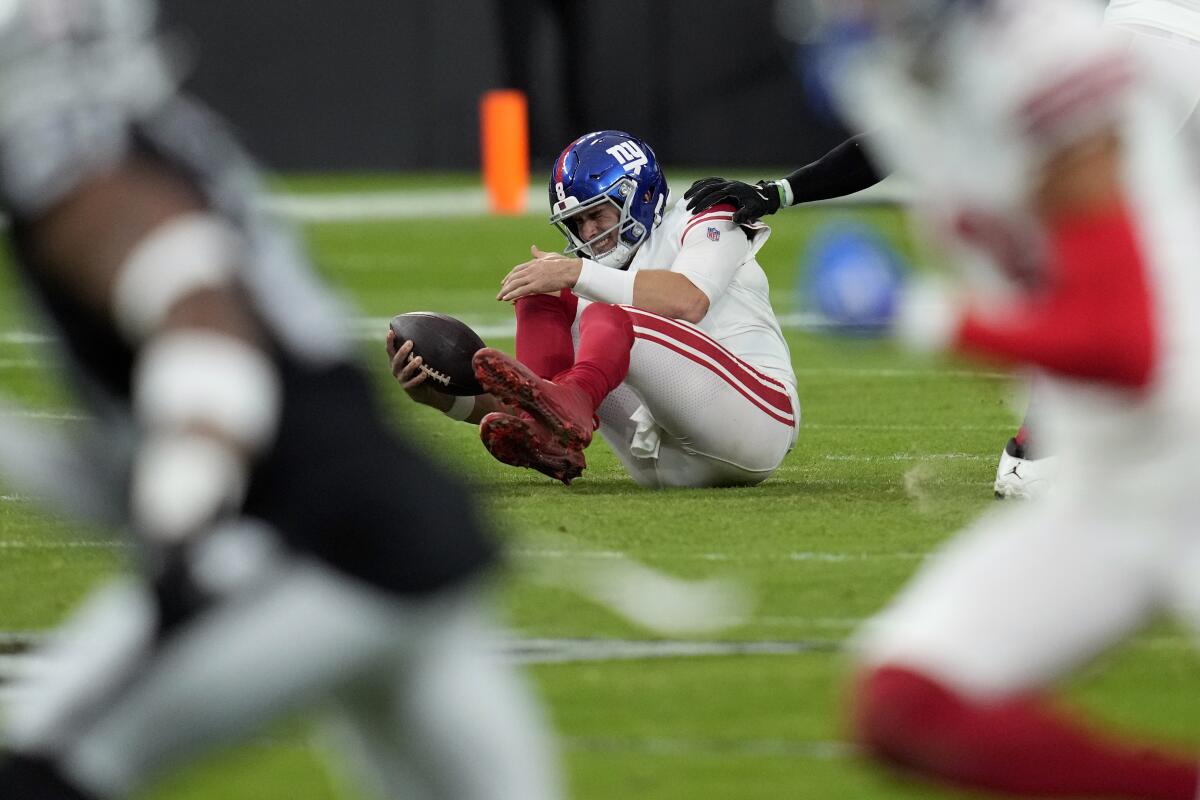 New York Giants quarterback Daniel Jones grimaces after hurting his knee on a sack by the Raiders.