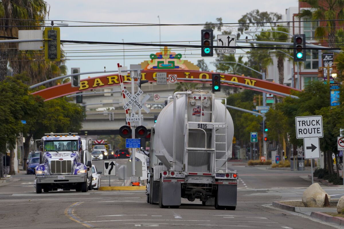  Large semi trucks hauling goods, drive along Harbor Drive and Cesar E. Chavez Parkway in Barrio Logan.