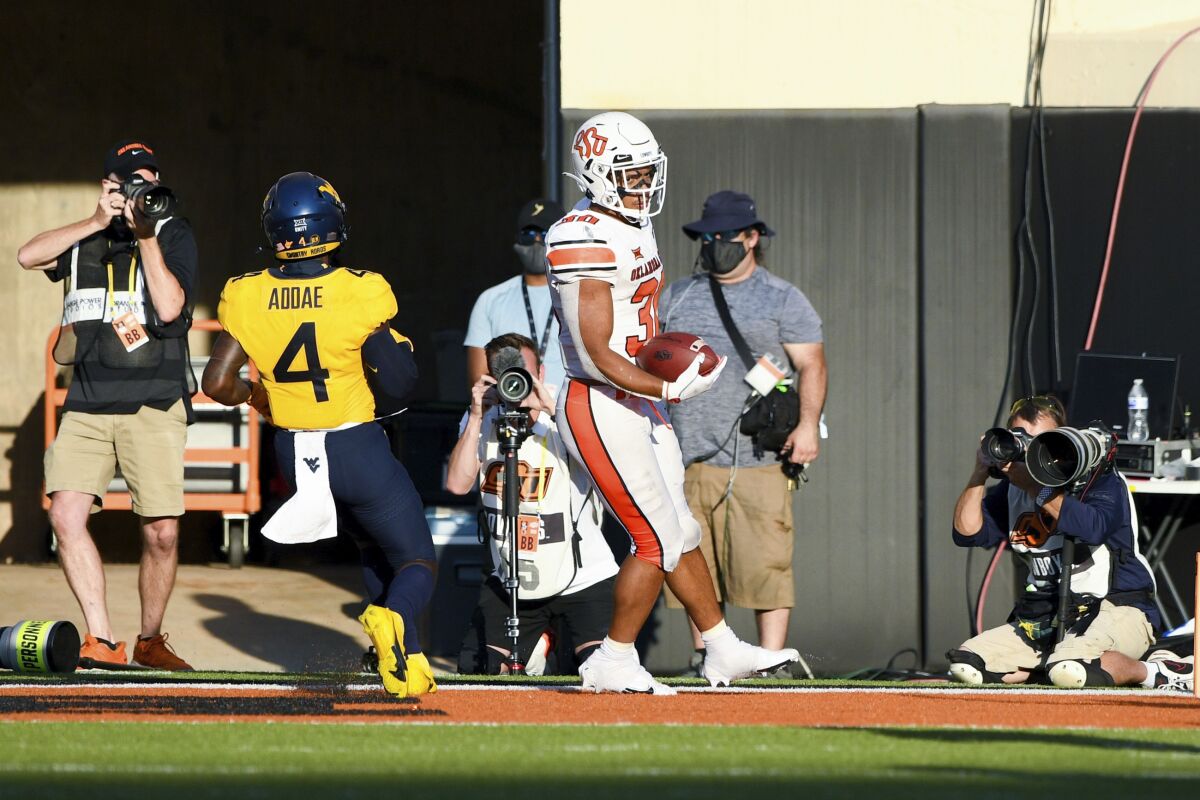 Oklahoma State running back Chuba Hubbard (30) scores a touchdown during the second half of an NCAA college football game against West Virginia Saturday, Sept. 26, 2020, in Stillwater, Okla. (AP Photo/Brody Schmidt)