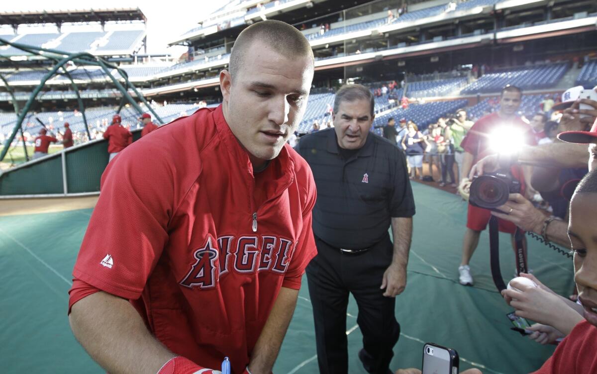 Angels outfielder Mike Trout signs autographs before the start of Tuesday's game against the Philadelphia Phillies.