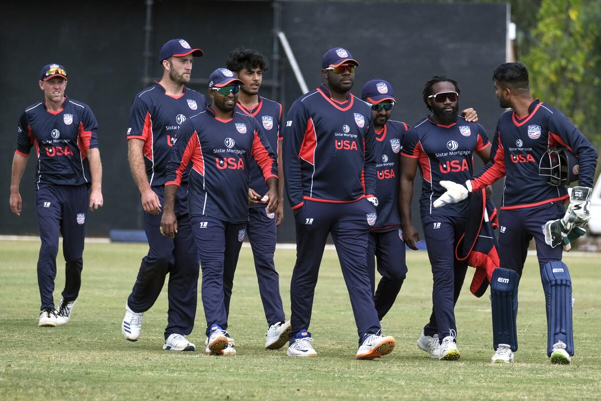 United States cricket players walk off the pitch after beating Singapore by 132 runs in a cricket World Cup qualifier match in Bulawayo, Zimbabwe, Tuesday, July, 12, 2022. The U.S. has advanced to the semifinals in Zimbabwe of a qualifying tournament for the T20 World Cup in Australia in October. One more win, and the Americans are in. (AP Photo/KB Mpofu)